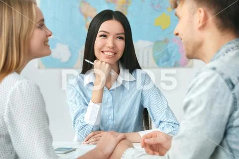 Young couple in a tour agency communication with a travel agent travelling Stock Photos