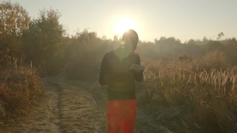 Young couple trail running through pikelets field. Man waving to woman to follow Video stock 166159810