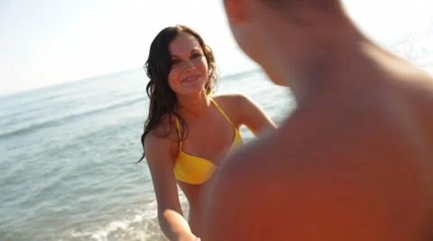 Young couple twirling on beach Stock Footage 43618098