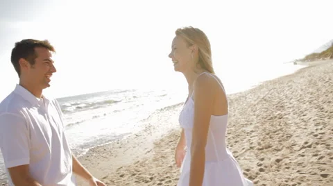 Young couple twirling on beach Stock Footage 43619080