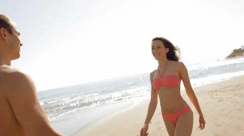 Young couple twirling on beach Stock Footage 43619903