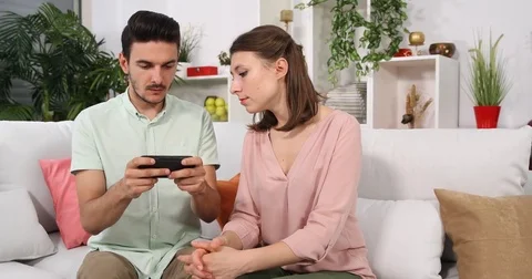 Young Couple Typing Message on Mobile Phone Sending to Friends Sitting Home Sofa Stock Footage 85454007