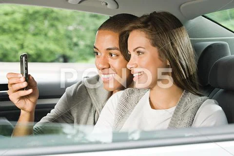 Young couple using a cellular phone in car Stock Photos