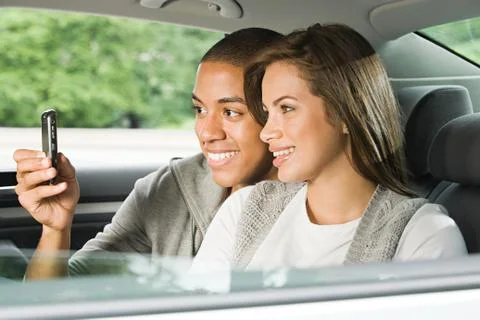 Young couple using a cellular phone in car Stock Photos