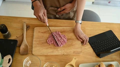 Young couple using cleaver knife mincing raw pork on wooden board, preparing Stock-Footage 264993817