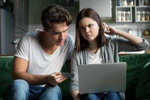 Young couple using computer and credit card at home Foto stock