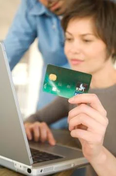 Young couple using credit card on internet Stock Photos