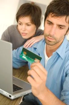 Young couple using credit card on internet Stock Photos