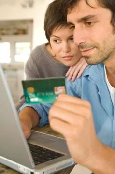 Young couple using credit card on internet Stock Photos