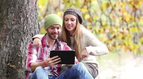 Young couple using a digital tablet in forest Video stock 57377208