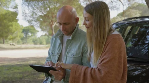 Young couple using digital tablet near car Stock Footage 107402450