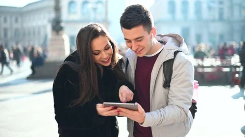 Young couple using a digital tablet outdoor while visiting a city Stock Footage 126595353