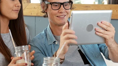 Young couple using digital tablet computer in cafe. Stock Footage 199634336