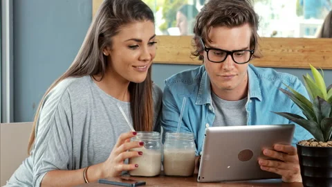 Young couple using digital tablet computer in cafe. Stock Footage 199634593