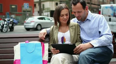 Young couple using electronic tablet in the city HD Stock Footage 10881761