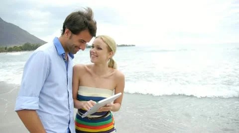 Young couple using electronic tablet on beach Video stock 14827812