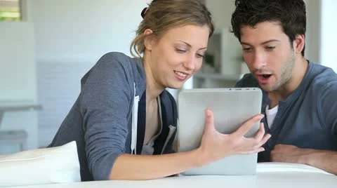 Young couple using electronic tablet Stock Footage 14829509