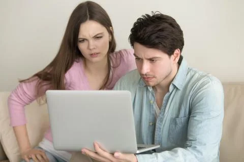 Young couple using laptop computer, having problems, anxious and 库存照片