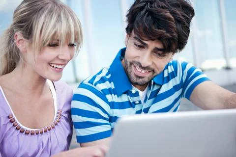 Young couple using laptop, smiling Stock Photos