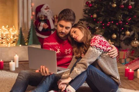Young couple using laptop together at christmas Stock Photos