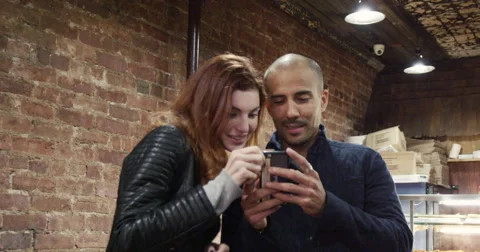 Young couple using mobile phone in pizza shop Vídeo Stock 63373633