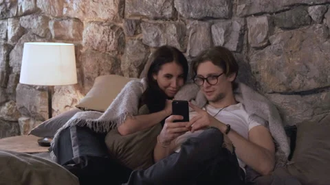 Young couple using smart phone with happiness on bed in the Evening Stock Footage 137177828