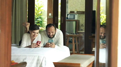 Young couple using smartphone in the bedroom Stock Footage 64272418