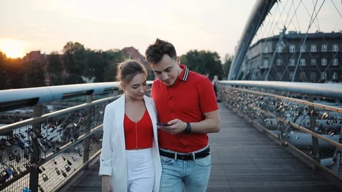 Young couple using smartphone on bridge in city smile attractive beautiful Stock Footage 95449962