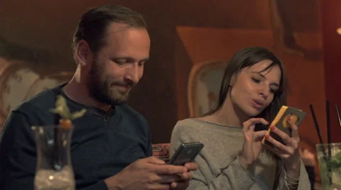 Young couple using smartphone sitting in cafe 動画素材 59859846