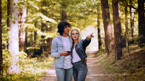 Young Couple Using Smartphone While Walks Through Forest Video stock 89893748