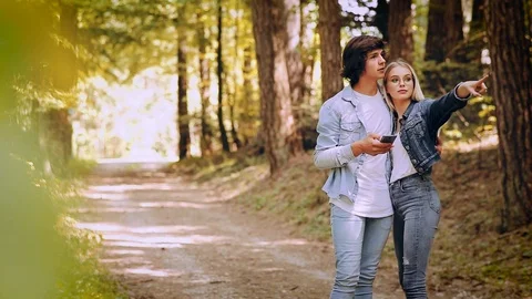 Young Couple Using Smartphone While Walks Through Forest Stock Footage 89893865