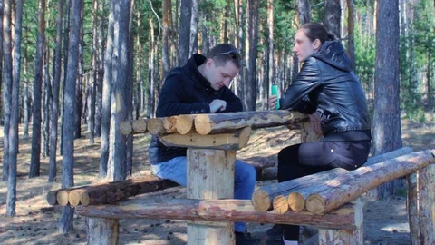 Young couple using smartphones and chatting. Having rest in autumn park forest Stock Footage 75671252