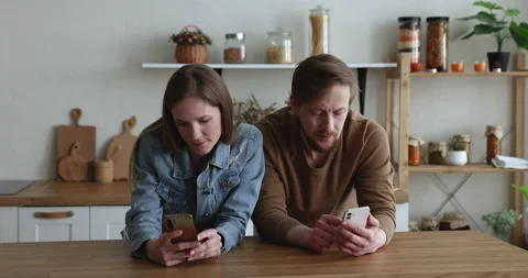 Young couple using smartphones, ignoring each other Stock Footage 229524476