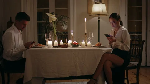 Young couple using smartphones romantic evening. Man woman ignoring each other Stock Footage 232729940