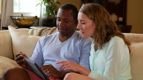 Young couple using tablet on couch Stock Footage 53015032