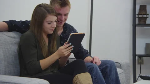 Young couple using tablet in living room Video stock 67363600