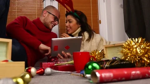 Young couple using tablet pc. Christmas time. 50 fps. Stock Footage 57369260