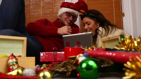 Young couple using tablet pc. Christmas time. 50 fps. Stock Footage 57369378