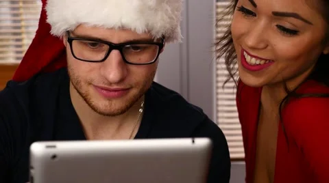 Young couple using tablet pc. Christmas time. 50 fps. Stock Footage 57369541