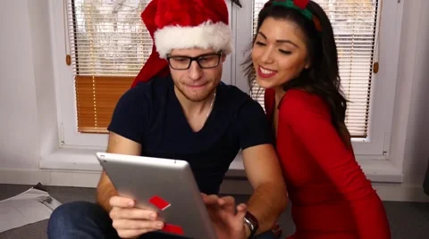 Young couple using tablet pc. Christmas time. 50 fps Stock Footage 57369589