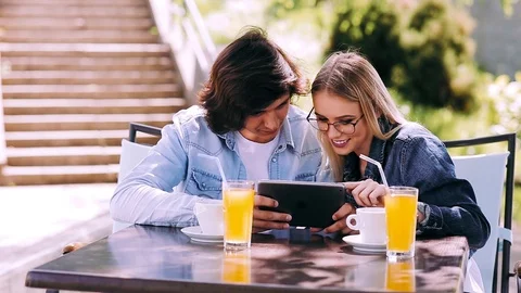 Young couple using tablet while sitting together at cafe Stock Footage 89825239
