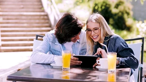 Young couple using tablet while sitting together at cafe Stock Footage 89825442