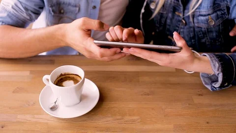 Young Couple Using Tablet While Sitting Together And Drinking Coffee Stock Footage 89828919