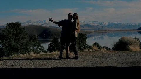 Young couple videographers smiling at camera by scenic Topaz Lake... Stock Footage 328254596