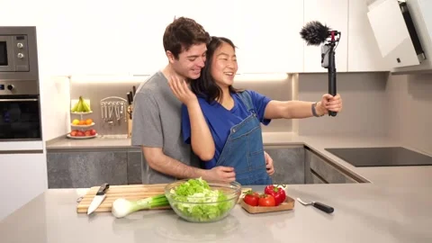 Young couple vlogging their salad preparation in kitchen Stock Footage 305236935