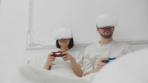 Young couple in VR headsets using controllers to play videogame Stock Footage 157212467
