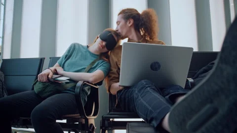 Young couple waiting for delayed flight at airport terminal Stockbeeldmateriaal 334563521