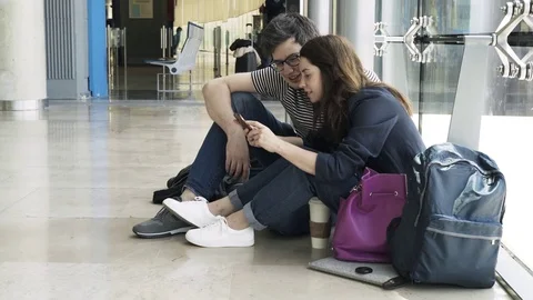 Young couple is waiting for their flight in Valencia airport, side view 库存影片 79458577