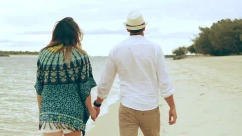 Young couple walking along the beach holding hands and smiling near water in Aus Stock Footage 199459695
