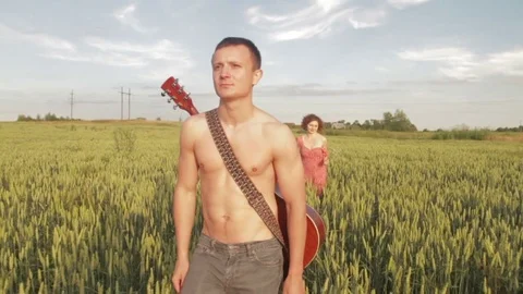 A young couple is walking along the wheat field. Stock Footage 78655785